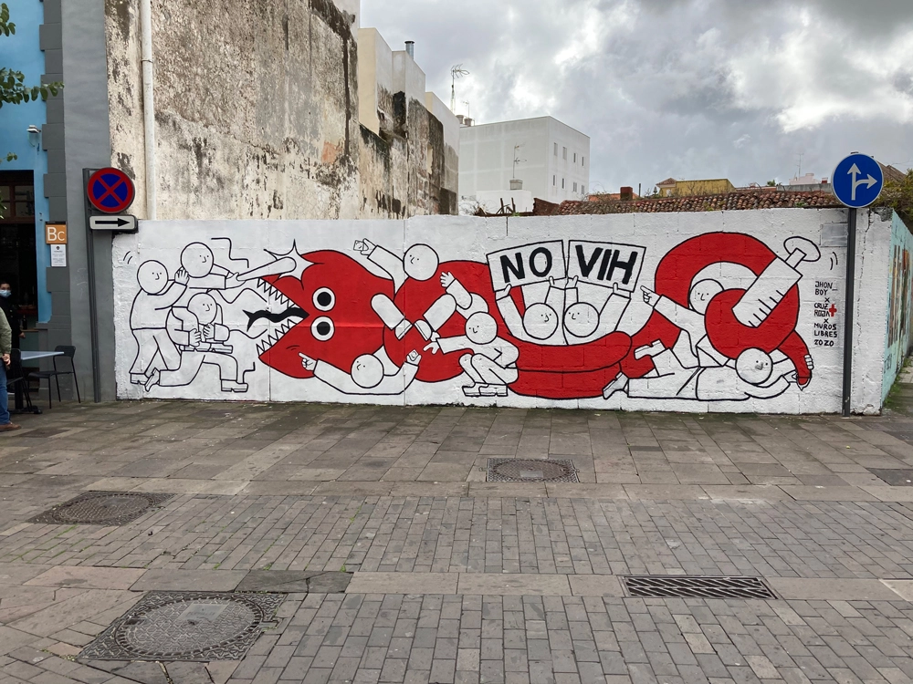 a urban art mural of characters and persons fighting a giant red snake